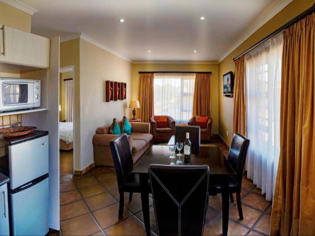 Self-catering suite with dining table, lounge area, and kitchenette.