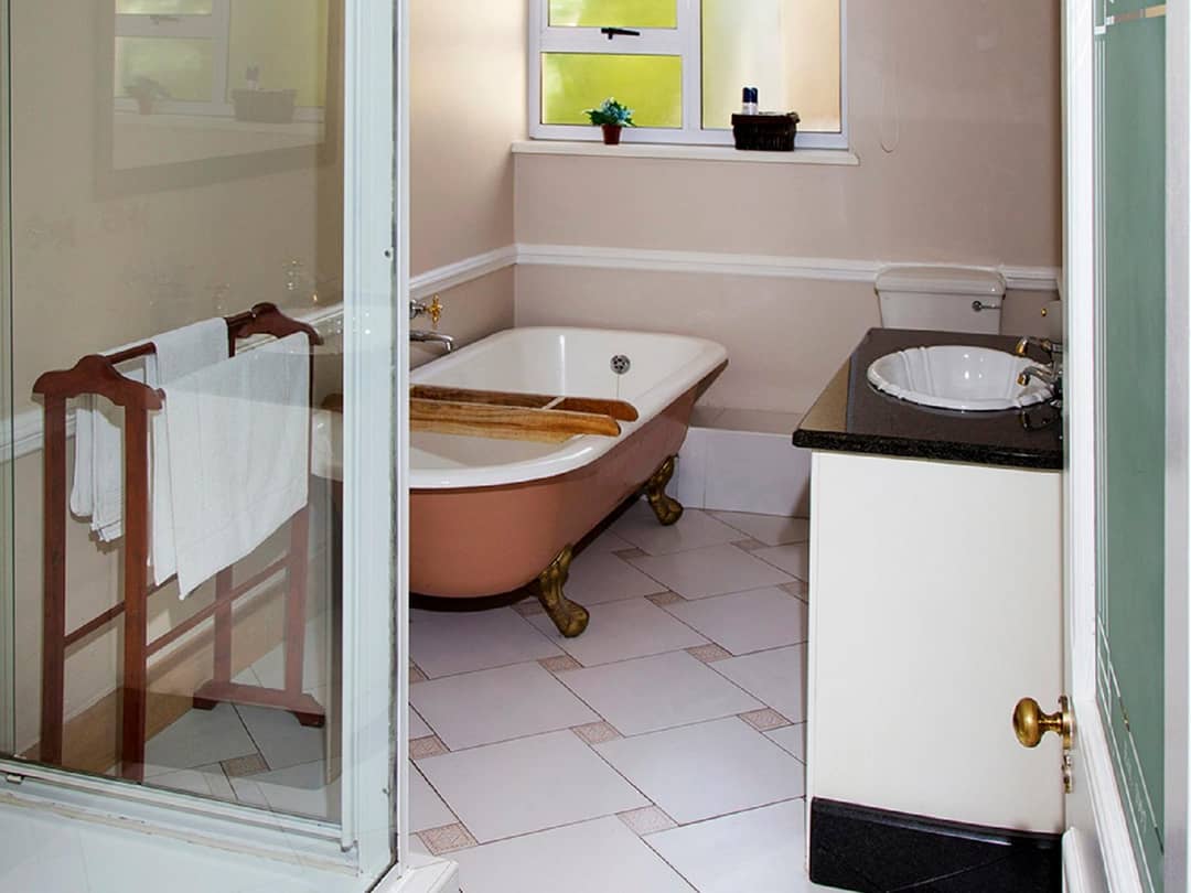 Bathroom with clawfoot tub, vanity sink, and towel rail.