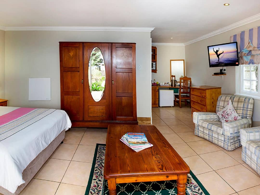 Spacious room with antique wardrobe, seating area and kitchenette nook.
